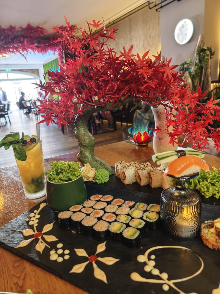 Kreativ angerichtete Sushi-Platte mit hausgemachten Vorspeisen und Cocktail im KIZUNAM Asian Fusion Restaurant in Bayreuth.